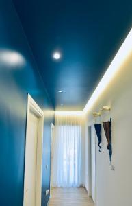 a room with a blue ceiling and a hallway at Ciotola Apartment 5 minuti dall' Aeroporto di Napoli in Naples