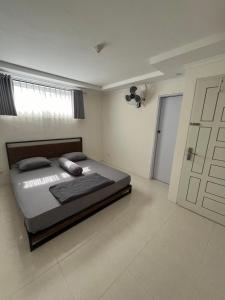 een slaapkamer met een bed, een raam en een deur bij Giggsy Homestay at Belakang Balok in Bukittinggi