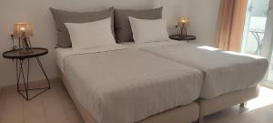 a bedroom with a large bed with two lamps at Maria Studios in Parikia