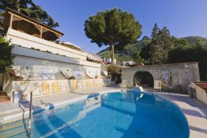 a swimming pool next to a building with a house at Resort Villa Flavio in Casamicciola Terme
