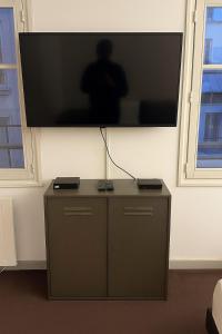 a flat screen tv hanging on a wall at Charming studio at the foot of the Opera-Le Petit Pradel in Lyon