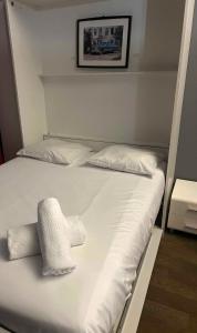 a bed with white sheets and pillows on it at Charming studio at the foot of the Opera-Le Petit Pradel in Lyon