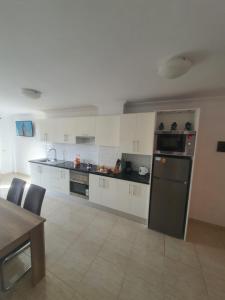 a kitchen with white cabinets and a black refrigerator at Angel House in Los Abrigos +12 photos
