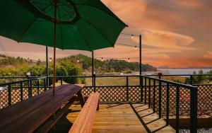 una panchina di legno con un ombrellone verde su un balcone di Hotel Ryan a Sacheon
