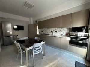 a kitchen with a table and chairs and a sink at Casa Neghelli - Alassio in Alassio