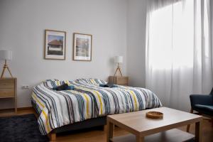 a bedroom with a bed and a table and a chair at Búzavirág Apartmanok in Oszkó