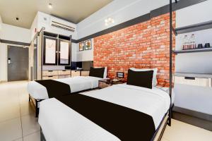 Super Townhouse Oak Mangalore客房内的一张或多张床位
