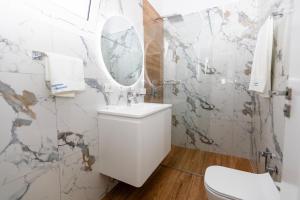 łazienka z toaletą, umywalką i lustrem w obiekcie Lungomare Apartments we Wlorze +47 zdjęć