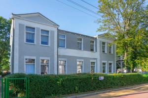 a gray house with a fence in front of it at O.W.Cynamon in Dziwnów +25 photos