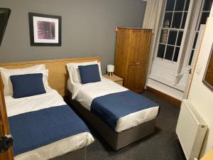 a bedroom with two beds and a window at Blue Boar in Frome