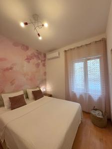 a bedroom with a white bed and a window at Guest House Štorija, Vis Center, 1 min from Ferry in Vis