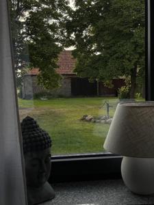 ein Fenster mit einer Kopfstatue neben einer Lampe in der Unterkunft Mams-Cottage-Doris in Harnischdorf
