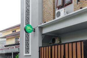 a green sign on the side of a building at Mono Coliving Benhil, Jakarta Pusat in Jakarta