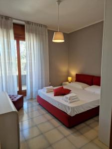 a bedroom with a large bed with a red headboard at A Casa da Maria in Melissano