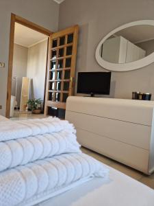 a bedroom with three white beds and a mirror at A Casa da Maria in Melissano