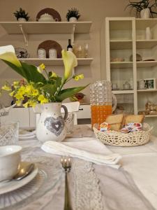 a table with a vase of flowers and a basket of bread at A Casa da Maria in Melissano