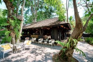 a patio with chairs and tables and a restaurant at Lampang River Retreat in Lampang +40 photos