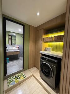 a laundry room with a washing machine and a mirror at Japandi Serenity 1 king,1 queen,1 single bed 5pax in Medan