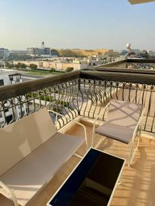 a balcony with a bench and a view of a city at Yas Island Studio Golf Escape in Abu Dhabi +7 photos