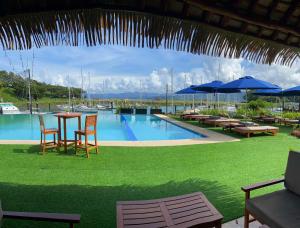a pool with chairs tables and umbrellas and a table at Nawi Island Marina Accommodation in Savusavu