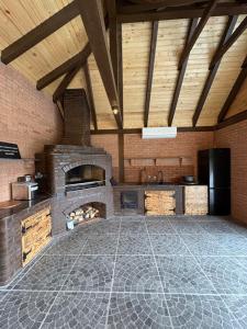 a large kitchen with a stone fireplace in a room at Vila Epic&Slanic Moldova in Slănic-Moldova