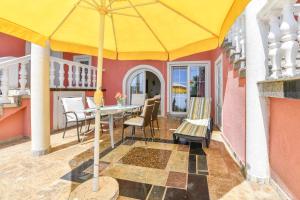 a dining room with a yellow umbrella on a patio at Villa Lilly 3 in Cesarica