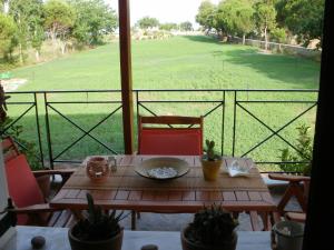 a table on a balcony with a view of a field at Gaea Gardens Studios & Villas in Petra