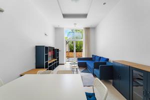 迪拜VayK - Spacious 2BR with Beach Access & Private Gym on Palm Jumeirah的客厅里有一张蓝色的沙发和一张桌子