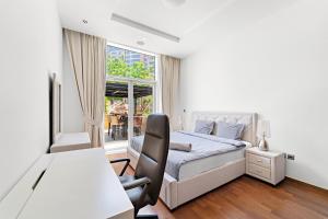 迪拜VayK - Spacious 2BR with Beach Access & Private Gym on Palm Jumeirah的一间卧室，配有一张床、一张书桌和一扇窗户