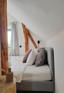 a bed with white sheets and pillows in a room at Chata Fraluq in Tatobity