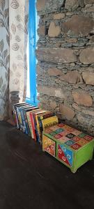 eine Reihe von Büchern neben einer Backsteinmauer in der Unterkunft Burans Kot Heritage Home - Ramgarh in Rāmgarh