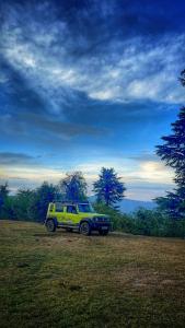ein gelber SUV, der auf einem Feld auf einem Feld geparkt ist in der Unterkunft Burans Kot Heritage Home - Ramgarh in Rāmgarh
