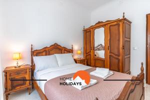 #306 Rua do Saco 11 by Home Holidays في ألبوفيرا: غرفة نوم مع سرير مع علامة العطل المنزلي عليه