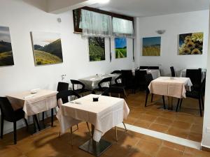 restauracja ze stołami i krzesłami oraz obrazami na ścianie w obiekcie Villa Tuscany Siena w Sienie