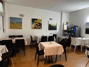 restauracja ze stołami i krzesłami oraz telewizorem w obiekcie Villa Tuscany Siena w Sienie