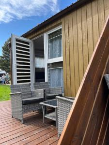 a patio with chairs and a table on a deck at Vila KOPA Šventoji in Šventoji