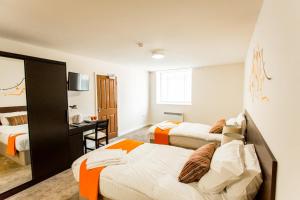 a hotel room with two beds and a desk at Whiteley Mill in Stapleford