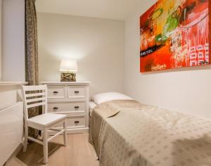 ein Schlafzimmer mit einem Bett, einem Stuhl und einer Kommode in der Unterkunft Viktoria 4 you - Whg. 04 in Westerland