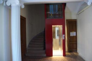 a hallway with a red door and stairs in a building at Alessandro in Trieste