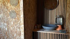 a bathroom with a bowl sink on a wooden shelf at Ecolodge premium avec bain nordique in Vallet