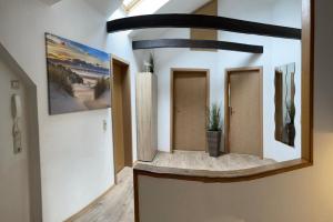 a hallway with three doors and a potted plant at Ferienwohnung Emmi in Nordenham +4 photos