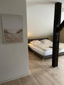 a bedroom with a bed and a picture of a beach at Ferienwohnung Emmi in Nordenham