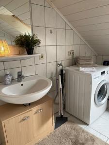 a bathroom with a washing machine and a sink at Ferienwohnung Emmi in Nordenham