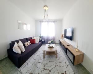 a living room with a blue couch and a table at proche de tout, confort clim et parking gratuit in La Celle-sous-Gouzon