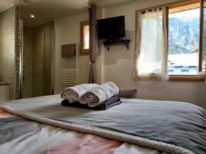 a bedroom with a bed with towels on it at Améthyste in Val-des-Prés