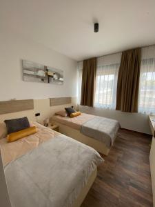 ein Zimmer mit drei Betten und Fenstern in der Unterkunft Villa Nika in Peroj