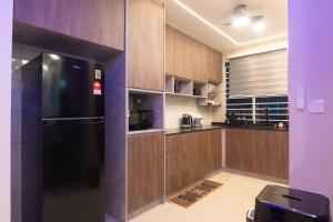 Una cocina con gabinetes de madera y un refrigerador negro. en Cozy 3BR Family Stay Duke High Way Free Parking, en Kuala Lumpur 13 fotos más