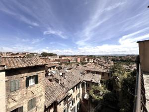 uitzicht op een stad met daken van gebouwen bij Abbadia Panoramic Terrace in Siena