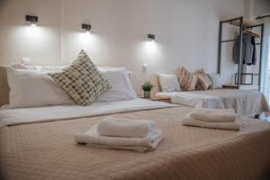 two beds with towels on them in a room at Nick Rooms in Stavros