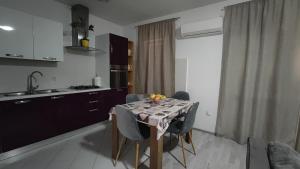 a kitchen with a table with chairs and a sink and a kitchen at Laura in Koromačno +22 photos